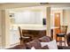View of basement bar with white cabinets, sleek countertop, and cozy seating at 930 W Dry Creek Rd, Littleton, CO 80120