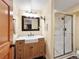 Bathroom featuring a wood vanity, farmhouse sink, and a glass-enclosed shower at 930 W Dry Creek Rd, Littleton, CO 80120