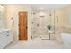 Bathroom features a neutral colored tile shower with glass doors and a soaking tub at 930 W Dry Creek Rd, Littleton, CO 80120