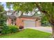 Beautiful two-story home with a brick facade, mature trees and lush green lawn at 930 W Dry Creek Rd, Littleton, CO 80120