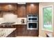 Gourmet kitchen with a double oven, granite counters, and custom wood cabinets at 930 W Dry Creek Rd, Littleton, CO 80120