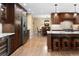 Open kitchen with stainless steel appliances, an island with bar seating and sightlines to dining area at 930 W Dry Creek Rd, Littleton, CO 80120