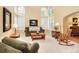 Bright living room featuring tall windows, comfortable seating, and hardwood floors, perfect for relaxation and entertaining at 930 W Dry Creek Rd, Littleton, CO 80120
