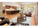 Open floor plan featuring hardwood floors, a large kitchen island with seating, and a living room with a large window at 930 W Dry Creek Rd, Littleton, CO 80120