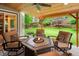 Covered patio featuring outdoor seating, a fire pit, and lush backyard views at 930 W Dry Creek Rd, Littleton, CO 80120
