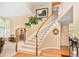 Elegant curved staircase with white railings, hardwood floors, and large windows, adding architectural charm to the home at 930 W Dry Creek Rd, Littleton, CO 80120