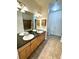 Bathroom featuring double sinks, spacious vanity, tile flooring, and a shower with a tiled enclosure at 17346 Nature Walk Trail Trl # 105, Parker, CO 80134