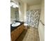 Cozy bathroom featuring tile flooring, vanity with sink and cabinet, toilet, and shower with decorative curtain at 17346 Nature Walk Trail Trl # 105, Parker, CO 80134