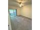 Bright bedroom with sliding glass door to a balcony, ceiling fan, and neutral carpeting at 17346 Nature Walk Trail Trl # 105, Parker, CO 80134