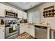 White kitchen cabinets, stainless steel appliances and wood flooring at 2389 Quartz St, Castle Rock, CO 80109