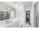 Modern bathroom featuring double sinks, a glass enclosed shower, and a walk-in closet at 39732 Penn Rd, Elizabeth, CO 80107