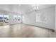 Light-filled living room features an abundance of natural light, hardwood floors and modern chandelier at 39732 Penn Rd, Elizabeth, CO 80107