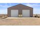 An exterior shot of the barn shows its two garage doors and clean concrete pad at 22990 County Road 30, Hudson, CO 80642