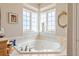 Relaxing soaking tub area with tiled surround, corner windows, and natural light at 22990 County Road 30, Hudson, CO 80642