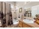 Bathroom featuring a shower-tub combo, earth tone tile, and single sink vanity at 22990 County Road 30, Hudson, CO 80642