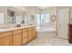 Bright primary bathroom with double vanity, a luxurious soaking tub, and tile flooring at 22990 County Road 30, Hudson, CO 80642