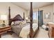 Bedroom with a four-poster bed, patterned bedding, and neutral walls, creating a cozy retreat at 22990 County Road 30, Hudson, CO 80642