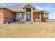 Charming front entrance with decorative pillars and lush green lawn at 22990 County Road 30, Hudson, CO 80642