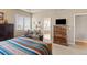 Relaxing primary bedroom with a colorful blanket, wooden furniture, and ensuite bathroom access at 22990 County Road 30, Hudson, CO 80642