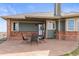 Covered brick patio with outdoor seating, offering a cozy space for entertaining and relaxing at 22990 County Road 30, Hudson, CO 80642