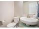 Cozy half bathroom featuring a pedestal sink and fresh neutral decor at 4532 Dewey Ln, Brighton, CO 80603
