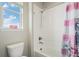 Bright bathroom with a white tiled shower/tub combo and decorative curtain at 4532 Dewey Ln, Brighton, CO 80603