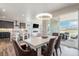 Open-concept living with dining area, showcasing access to outdoor patio and grill at 4532 Dewey Ln, Brighton, CO 80603