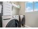 Well-lit laundry room with modern Samsung washer and dryer units and storage shelves at 4532 Dewey Ln, Brighton, CO 80603
