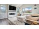 Bright living room featuring a fireplace, TV, and a view to the outside play area at 4532 Dewey Ln, Brighton, CO 80603