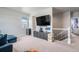 Spacious loft area with modern gray entertainment center and staircase at 4532 Dewey Ln, Brighton, CO 80603
