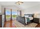 Bright primary bedroom featuring hardwood floors and abundant natural light from large windows at 3047 Deer Creek Ranch Loop, Parker, CO 80138