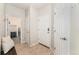 Hallway with tile flooring that leads to a laundry room and white doors at 3047 Deer Creek Ranch Loop, Parker, CO 80138