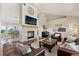 Cozy living room features a stone fireplace, hardwood floors, and comfortable leather furniture at 3047 Deer Creek Ranch Loop, Parker, CO 80138