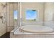Large tub featuring subway tile, a rain shower, and an outside view at 3047 Deer Creek Ranch Loop, Parker, CO 80138