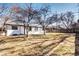 Fenced backyard featuring mature trees, a patio, and a view of the home's exterior at 507 S Pontiac Way, Denver, CO 80224