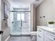 Modern bathroom features walk-in shower with glass door, white vanity, and neutral paint at 507 S Pontiac Way, Denver, CO 80224