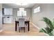 Bright dining room features wood floors, a modern chandelier, and view into the kitchen at 507 S Pontiac Way, Denver, CO 80224