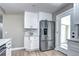 Kitchen featuring stainless steel refrigerator, white cabinets, backsplash, and natural light at 507 S Pontiac Way, Denver, CO 80224