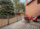 Wide shot of a wooden back deck featuring red outdoor furniture, railings, and trees at 1276 Harrison Ct, Boulder, CO 80303