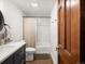 Bathroom featuring a tub shower, white subway tile, and a modern vanity with a wooden door at 1276 Harrison Ct, Boulder, CO 80303