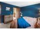 View of the bedroom featuring blue walls, a wooden dresser, and an open door at 1276 Harrison Ct, Boulder, CO 80303