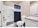 Bathroom featuring a tub/shower combo with blue shower curtain, toilet, and vanity at 18101 E 44Th Pl, Denver, CO 80249