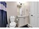 Bathroom with a white vanity, mirror, and blue shower curtain at 18101 E 44Th Pl, Denver, CO 80249