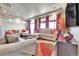 Open-concept living room featuring hardwood floors, large windows, and modern furnishings at 18101 E 44Th Pl, Denver, CO 80249