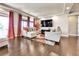 Bright living room boasts hardwood floors, recessed lighting, and large windows with curtains at 18101 E 44Th Pl, Denver, CO 80249