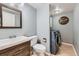 Bathroom and laundry area featuring vanity with a wood frame mirror, toilet, and blue front-loading washer and dryer at 398 Benton St, Castle Rock, CO 80104