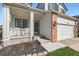 Welcoming covered front porch with seating area, leading to the front door and attached two-car garage at 398 Benton St, Castle Rock, CO 80104