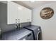 A laundry room featuring front-loading washer and dryer under white cabinets and a wooden laundry sign at 398 Benton St, Castle Rock, CO 80104