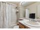 Well-lit bathroom featuring a shower-tub combo with a modern shower head and a stylish marble patterned curtain at 4733 Flower St, Wheat Ridge, CO 80033