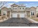 Inviting exterior view of a modern townhouse showcasing its stone accents and attached two-car garages at 4733 Flower St, Wheat Ridge, CO 80033